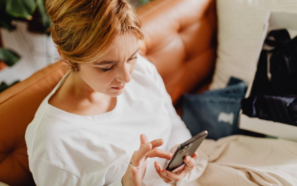 Una donna seduta mentre scrolla sul telefono