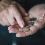 mani di una donna con delle monete in euro