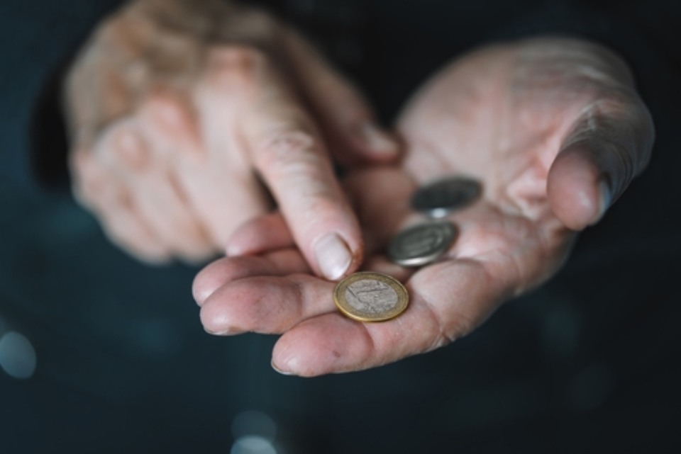 mani di una donna con delle monete in euro